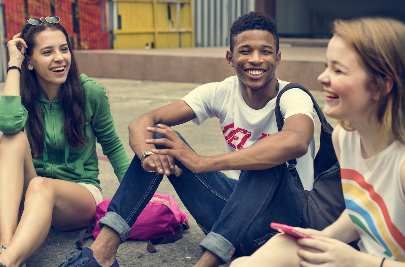 Vertical explainer photo 4 - Three teenagers sitting and talking while smiling